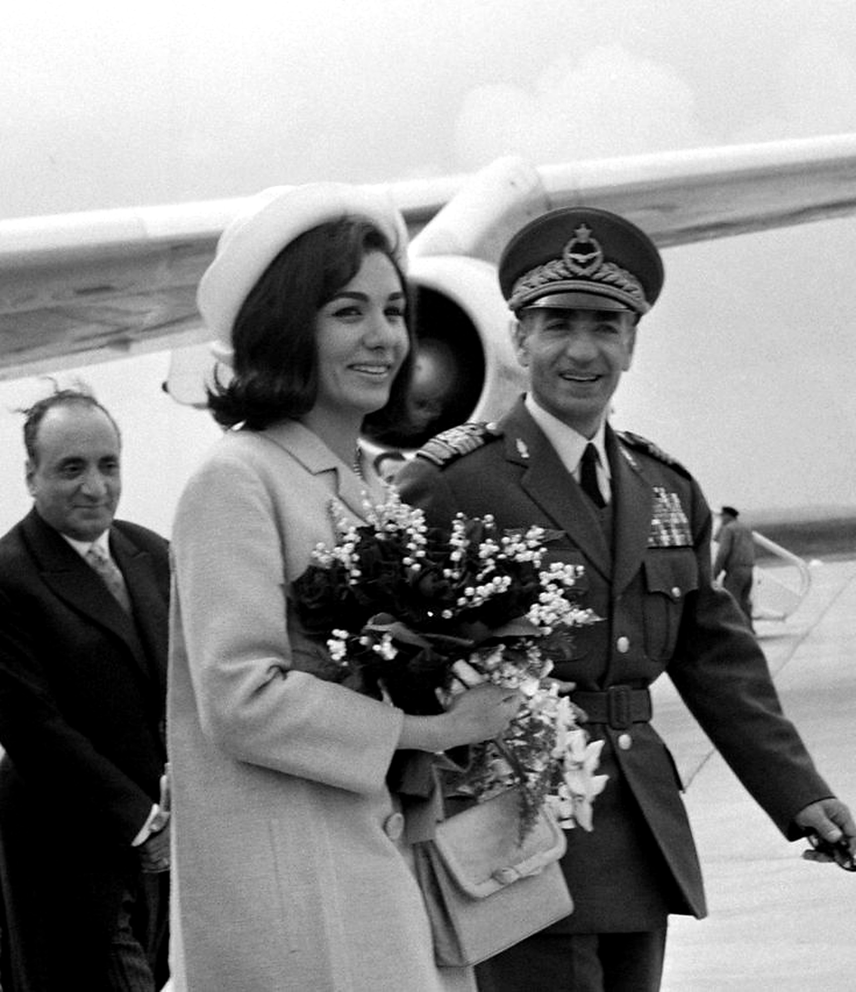 Farah Pahlavi and the Shah at an airport arrival.