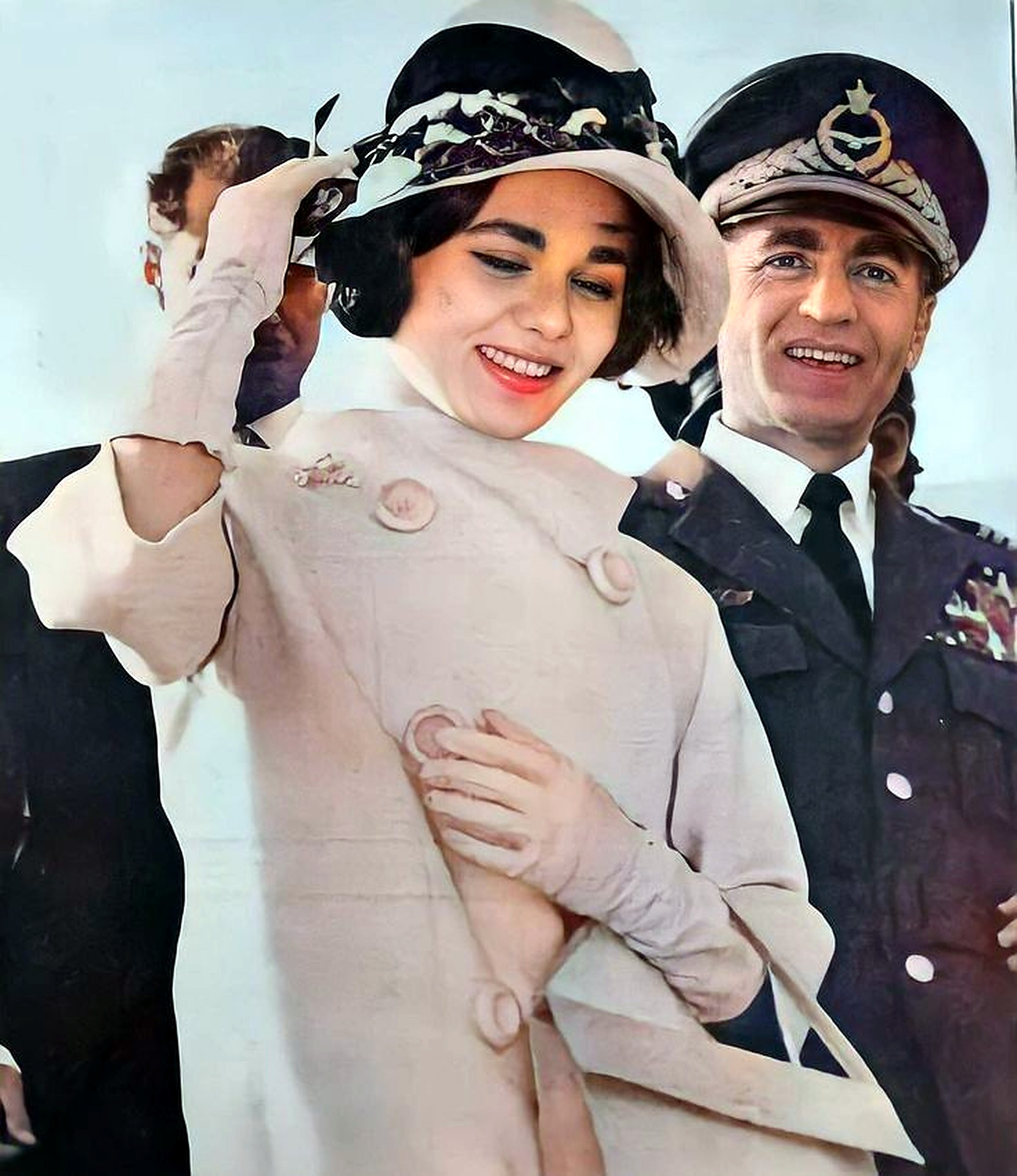 Farah Pahlavi adjusts her hat beside the Shah.