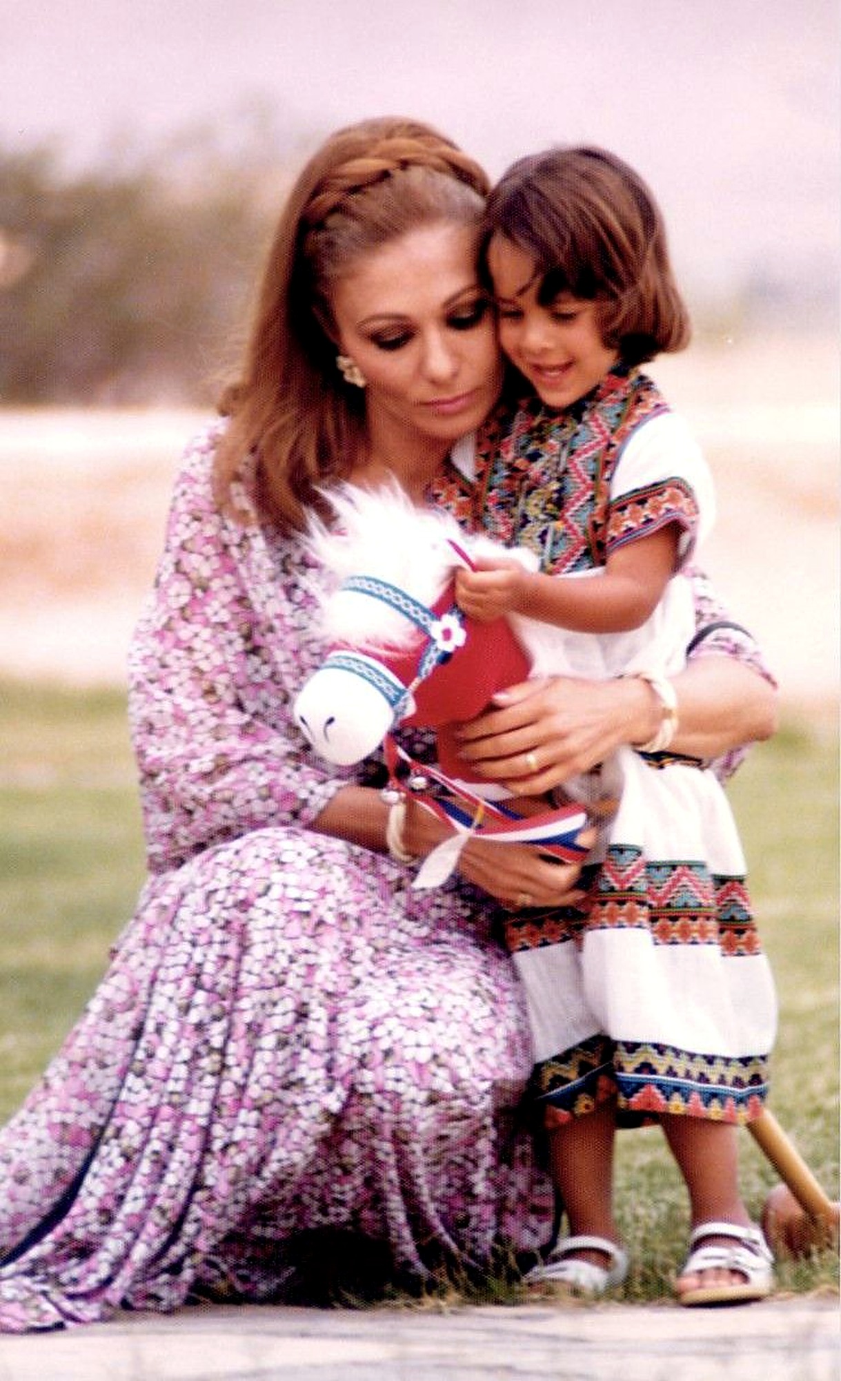 Farah Pahlavi with a young princess and a hobby horse.