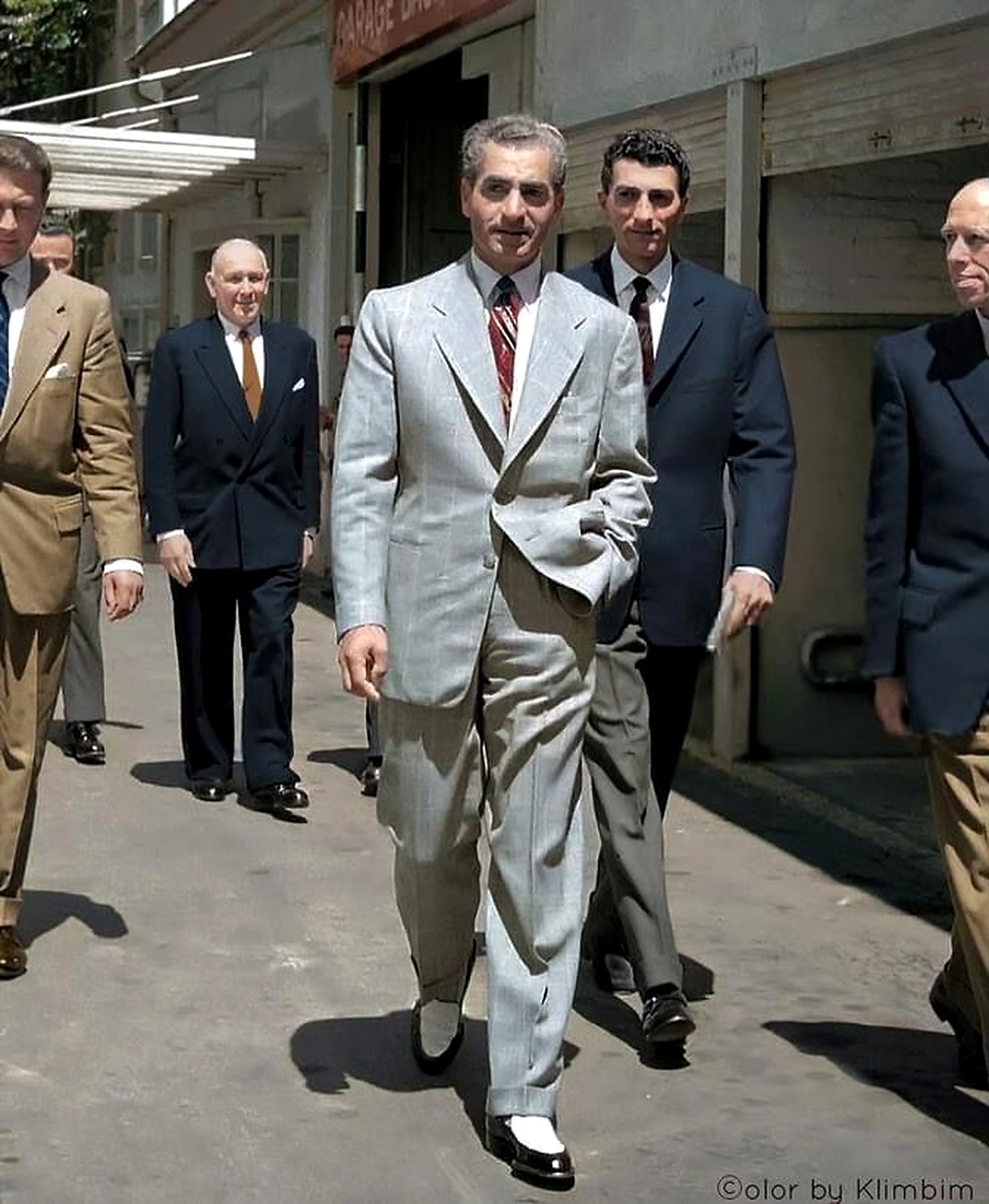 The Shah walking in a light suit.